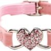 The Heart Bling Cat Collar with Safety Belt is a pink pet accessory that showcases a sparkling heart-shaped charm adorned with pink gems and comes with a silver bell, offering both style and security for your feline friend.