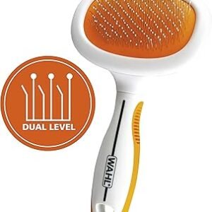 A pet grooming brush with an orange and white design, featuring "WAHL" on the handle. The Wahl Sensitive Skin Pet Slicker is perfect for sensitive skin, equipped with fine bristles and an orange emblem showcasing "DUAL LEVEL" in a stylized pattern of raised lines.