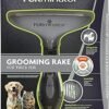 The packaging of the FURminator Grooming Rake for Cats features images of a dog and cat, emphasizing its ability to remove loose hair and prevent tangles. This grooming tool is perfect for cats with thick fur and includes a comfortable handle for easy use.