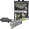 A FURminator Grooming Rake for Cats, featuring a wide, grey handle and metal teeth, is shown next to its packaging. The box includes images of two dogs and highlights its advantages for maintaining thick fur, reducing loose hair and tangles, making it an ideal option for both dogs and cats.