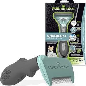 A FURminator Undercoat deShedding Tool Small, featuring a handle in teal and gray, is shown in front of its packaging. The packaging includes images of a cat and text that emphasizes the tool's effectiveness in reducing pet shedding.